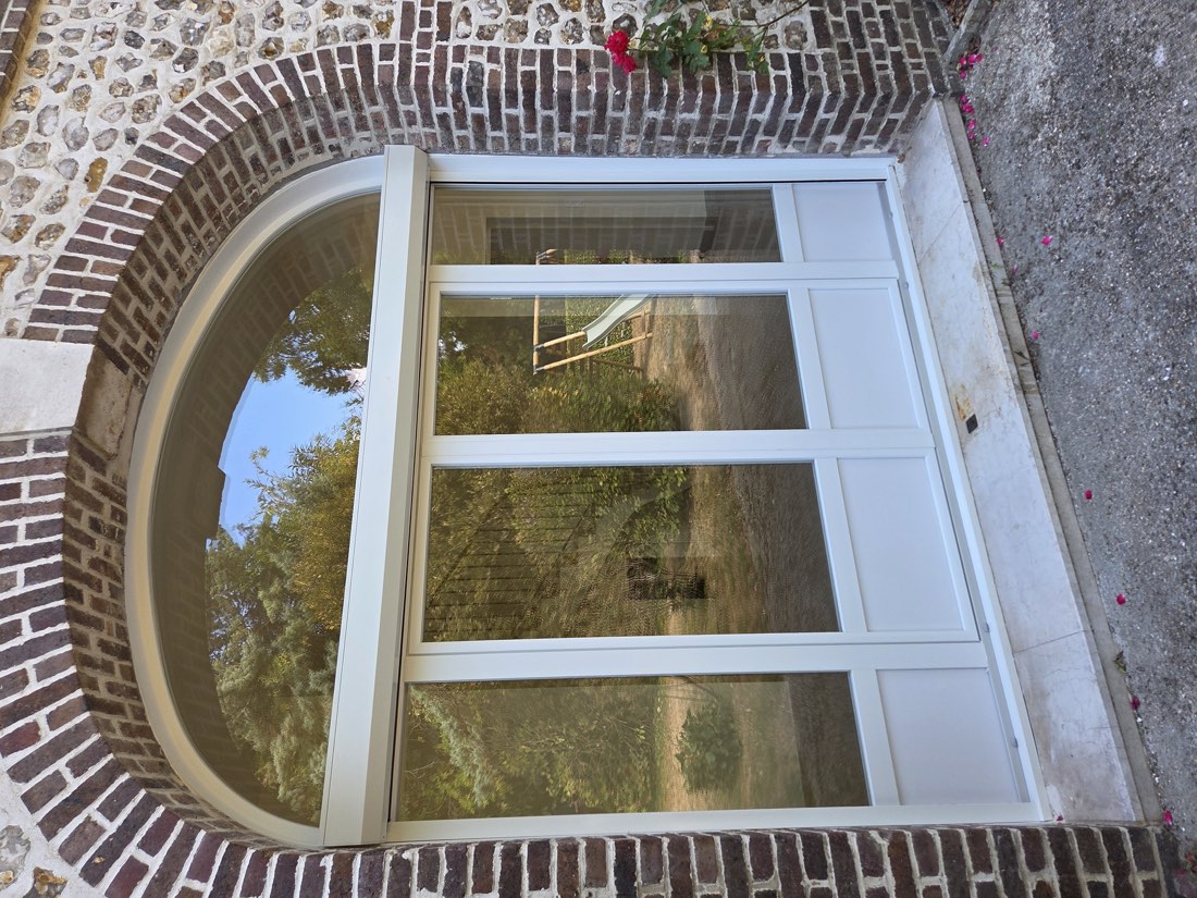Menuiserie cintrée sur mesure posée dans une arche de briques, maison normande — chantier IPM à Rouen