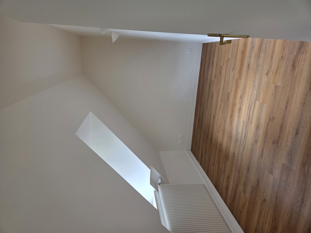 Chambre mansardée rénovée avec fenêtre de toit — chantier IPM à Rouen