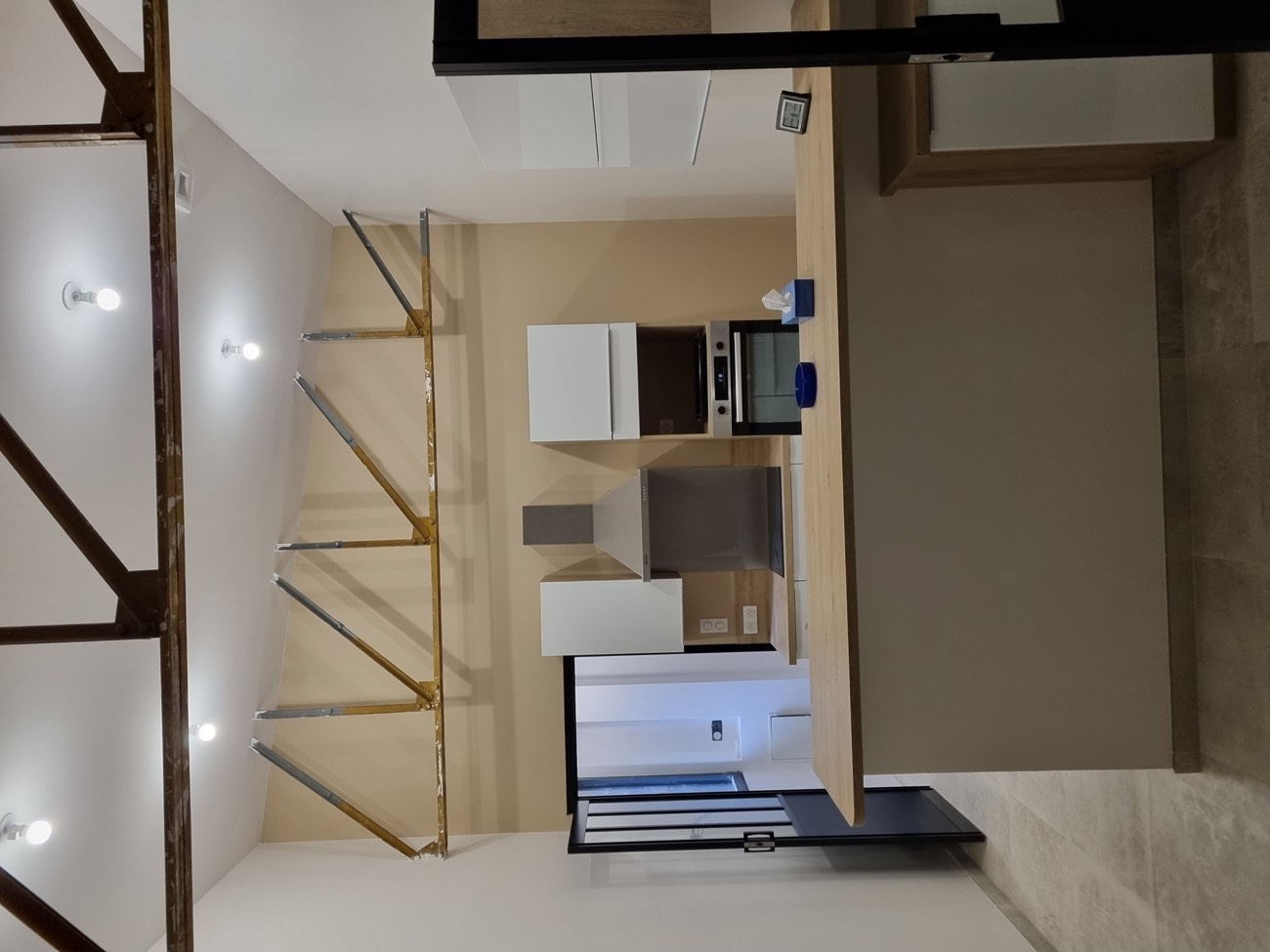 Ancien atelier transformé en pièce à vivre avec cuisine, plâtrerie et charpente métallique apparente — chantier IPM à Rouen